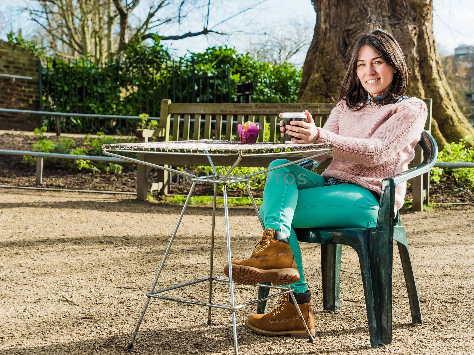 Beautiful Young Woman Sitting Alone in a Cafe Outdoor and Drinking a Cup of Tea Looking in Camera