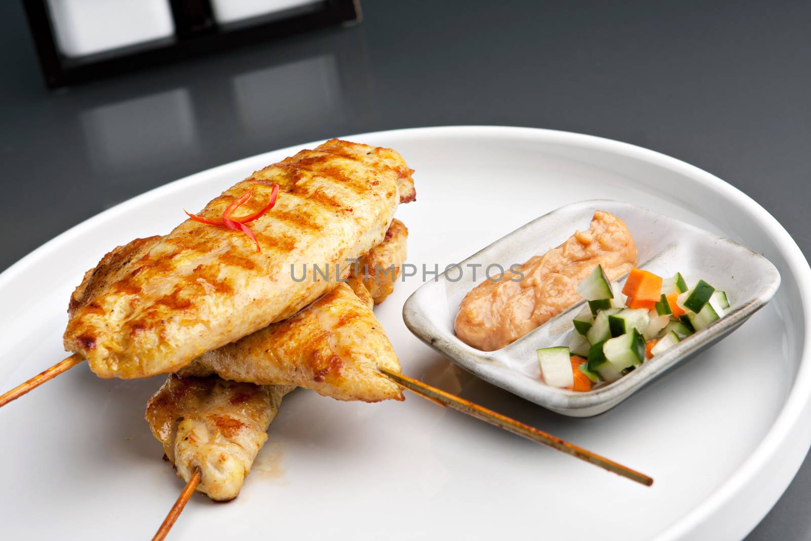 Asian style chicken satay barbecued chicken on skewers with peanut dipping sauce.