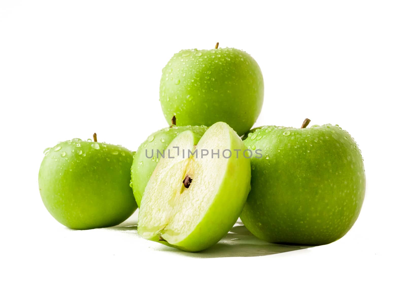 Group of granny smith apples covered with drops of water isolated over white.