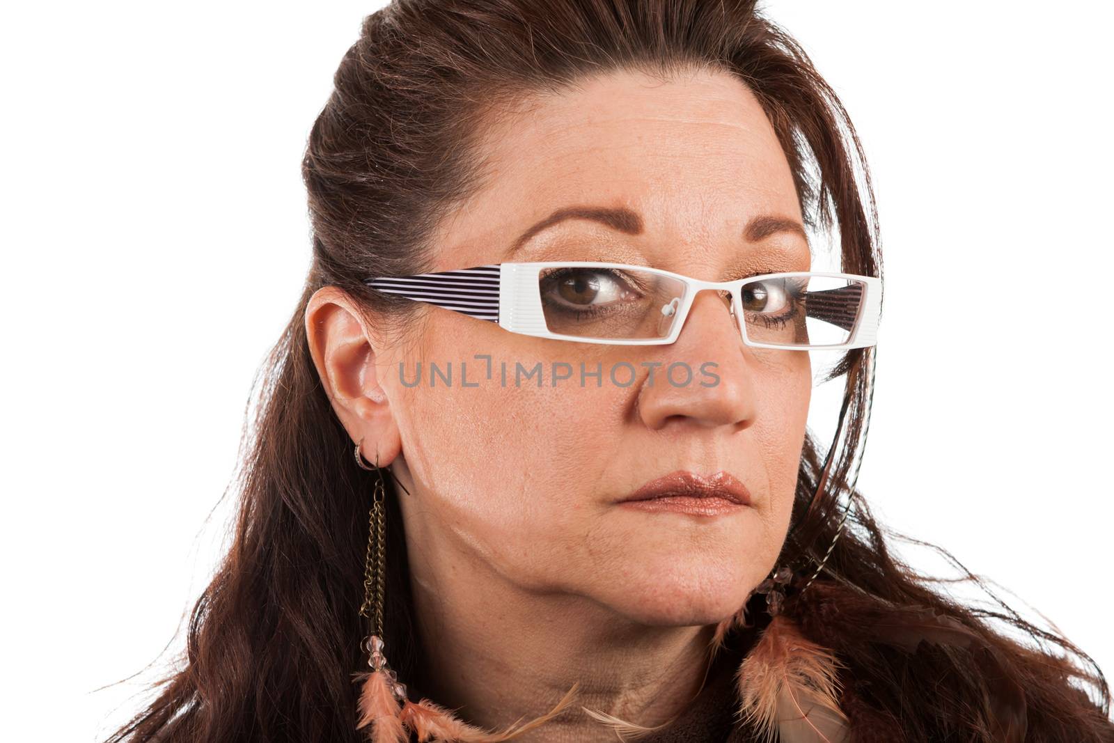 Brunette middle aged woman wearing white framed glasses with a serious expression.  Shallow depth of field.