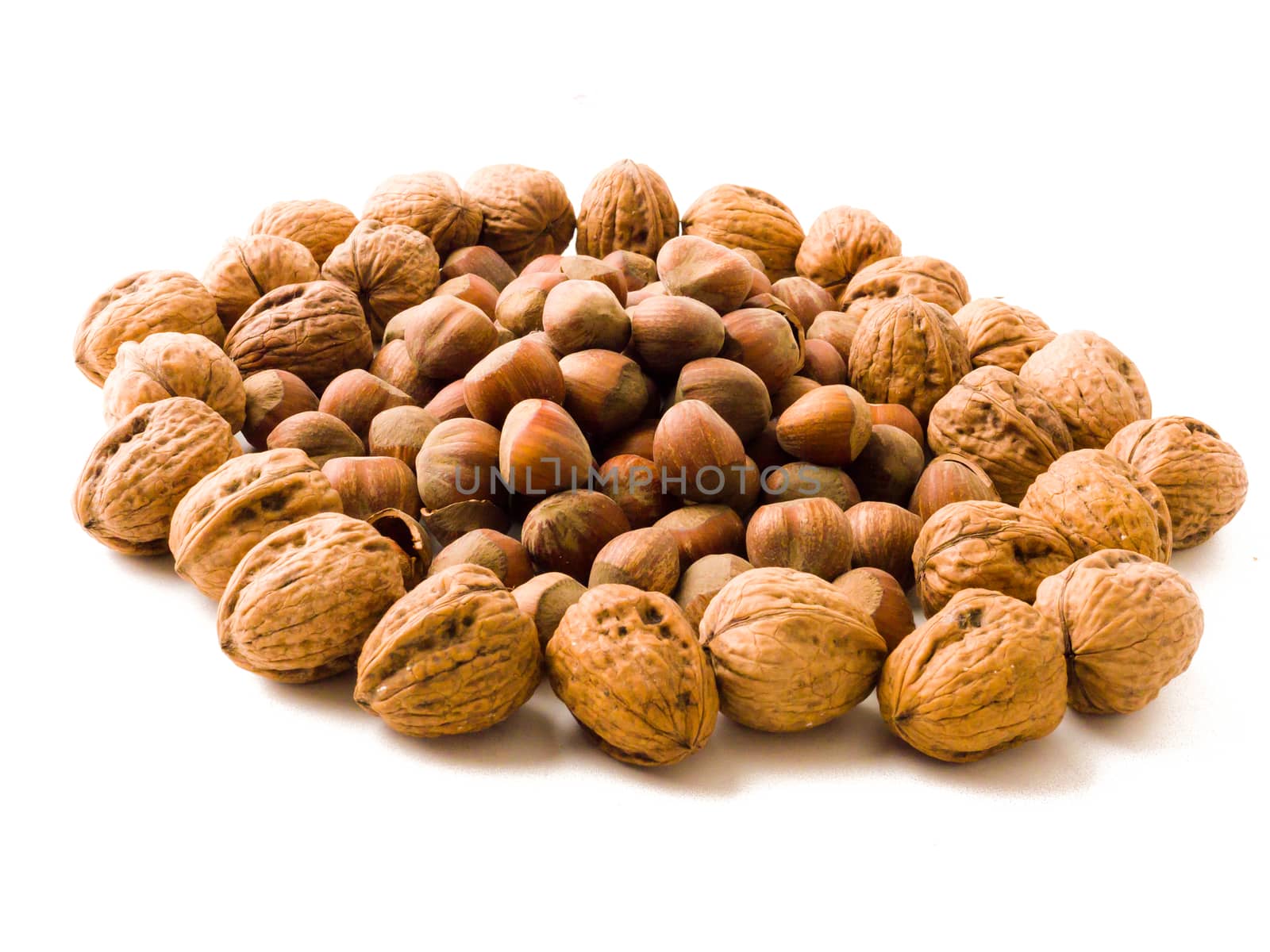Mixed nuts - hazelnuts, walnuts isolated over white background.
