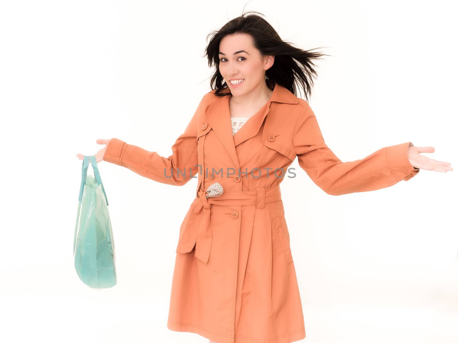 Shopping Woman in Coat Holding Shopping Bag. Beautiful Female Model Isolated on White Background