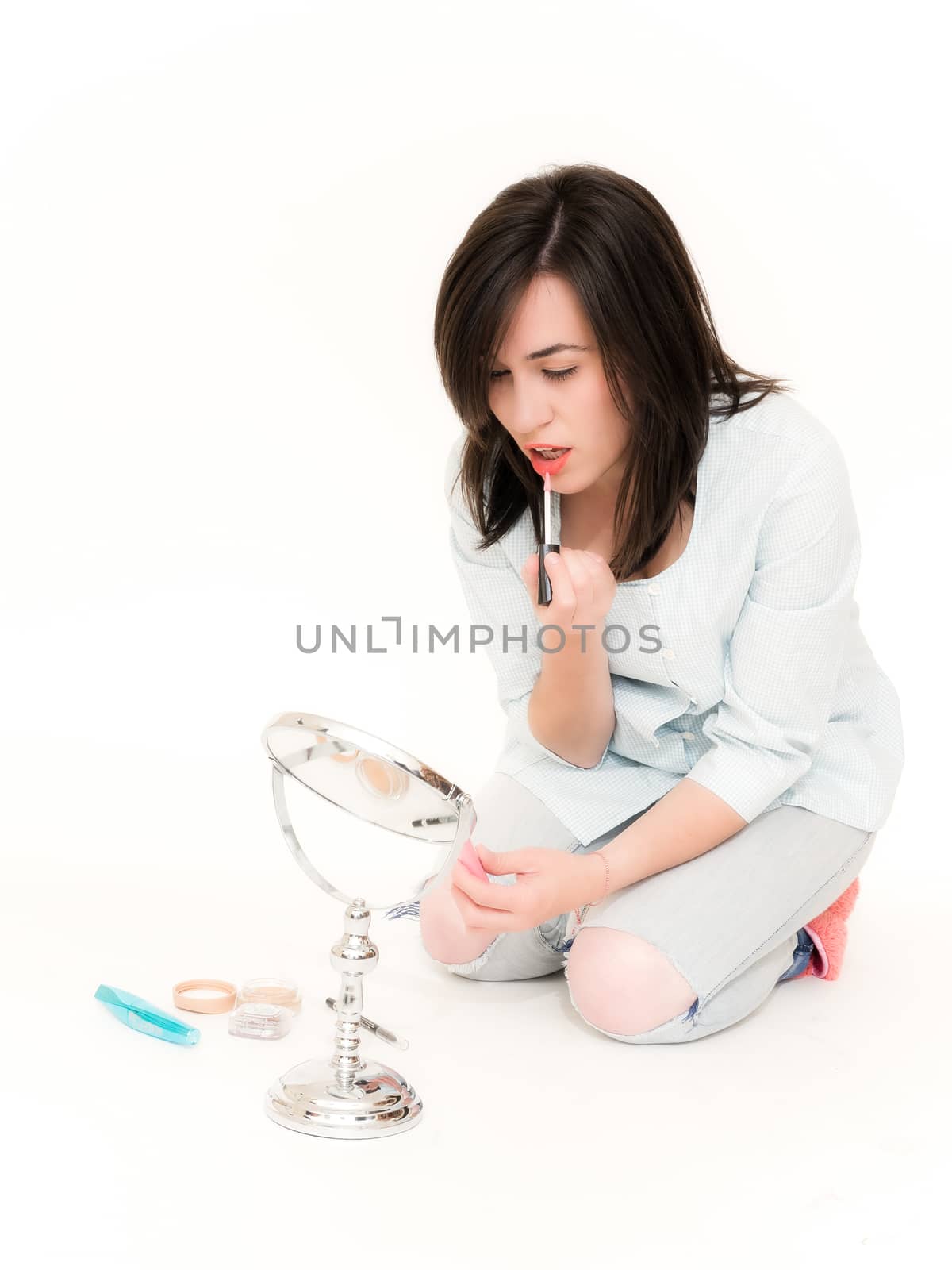 Young Woman Doing Her Makeup with a Lipstick Isolated on White Background