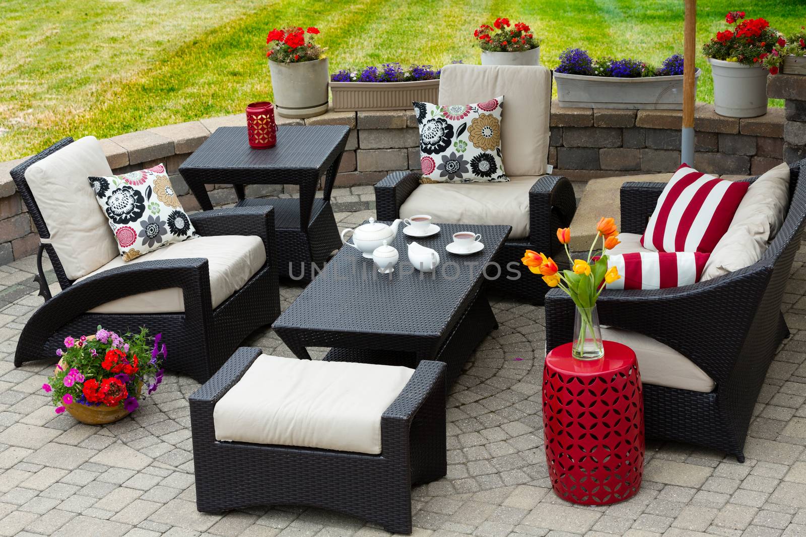 Overview of Upscale Patio Set, Dark Wicker Luxury Furniture with Comfortable Cushions on Outdoor Stone Patio of Affluent Home