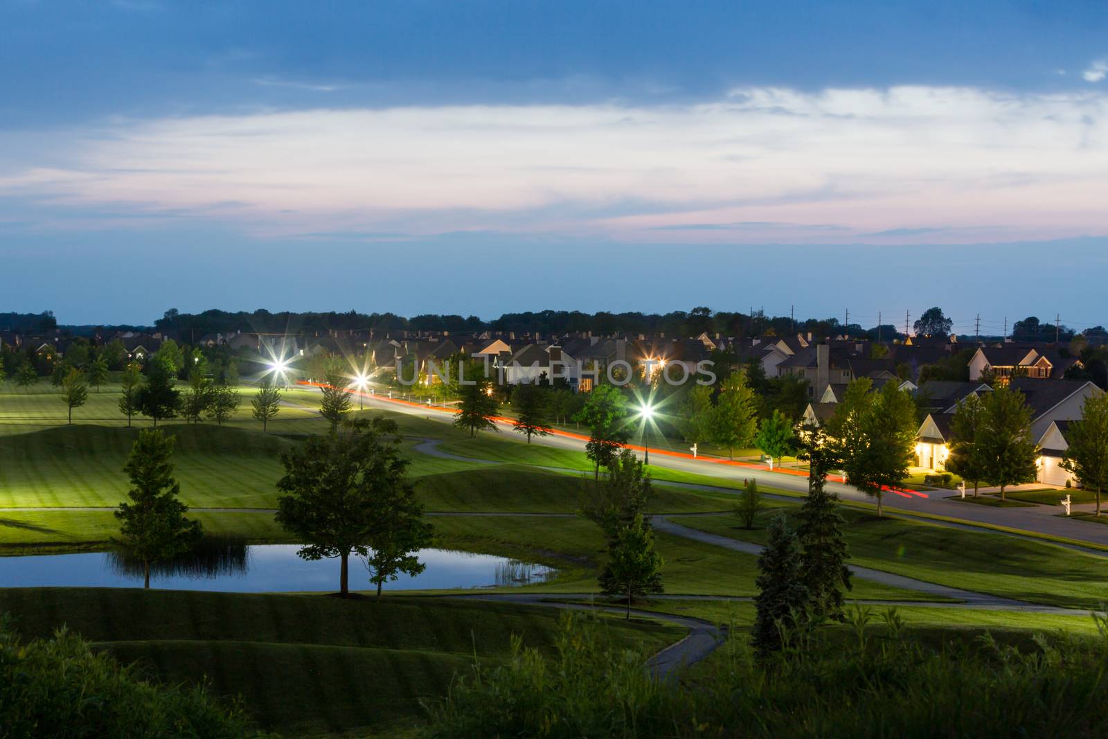 Overview of Luxury Neighborhood on Grounds of Golf Course at Dusk Illuminated by Street Lights