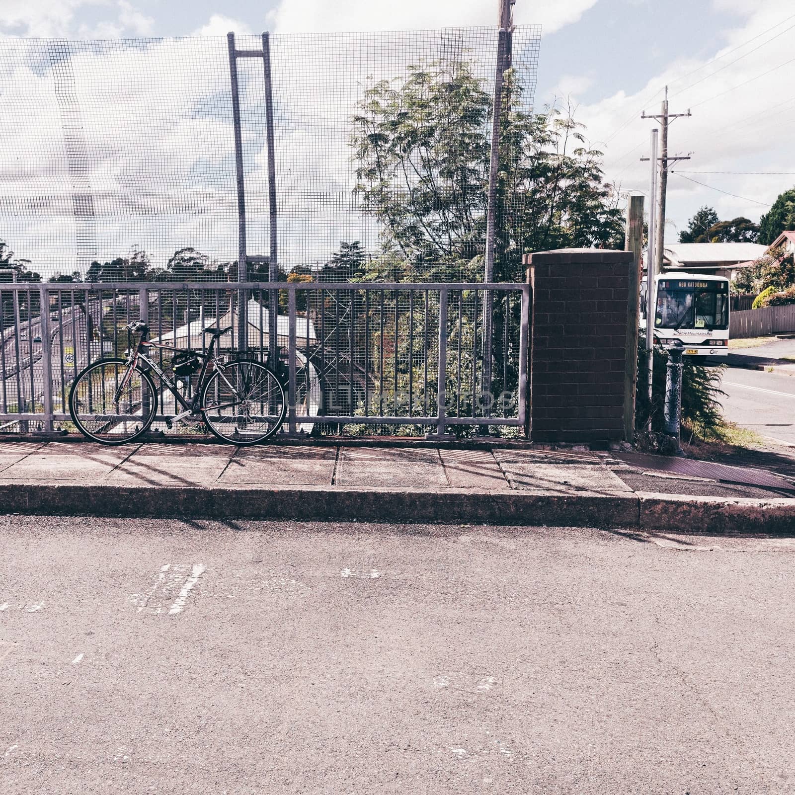 This photo from Hazelbrook, Blue Mountains, Australia, comprises four means of transportation: bus, bicycle, train and car.