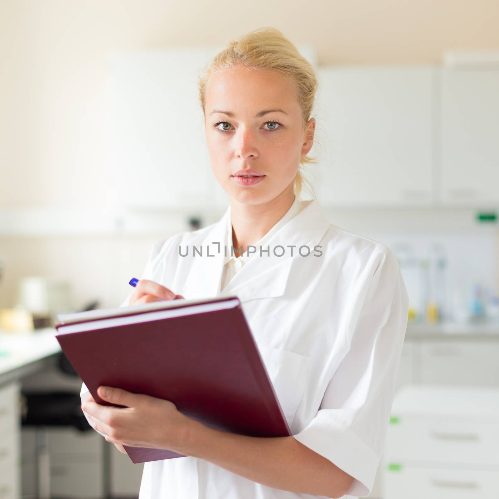 Portrait of an attractive, young, confident female health care professional in his working environment.