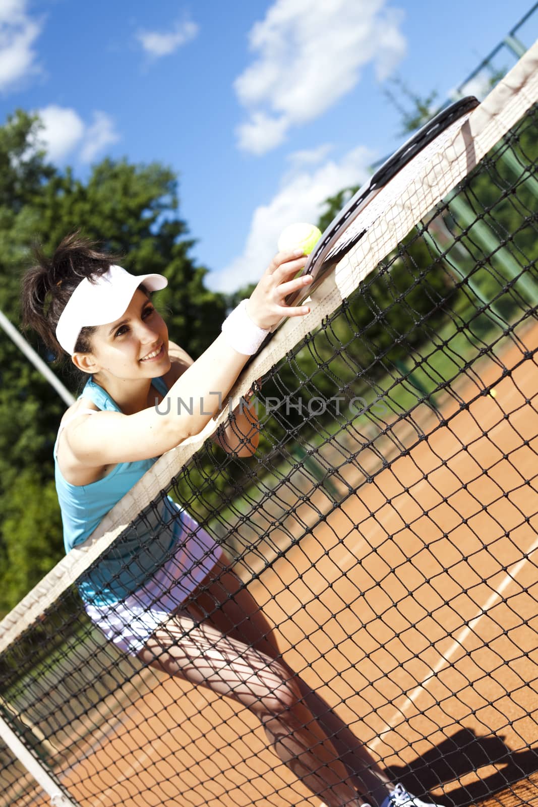 Girl playing tennis on the court by JanPietruszka