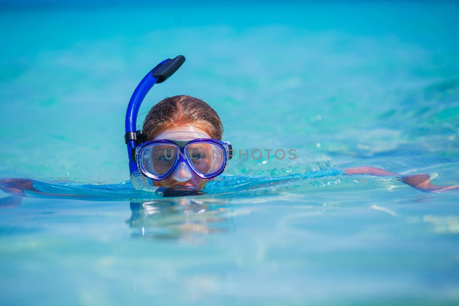 Portrait of happy cute girl wearing snorkeling mask ready to dive in the sea