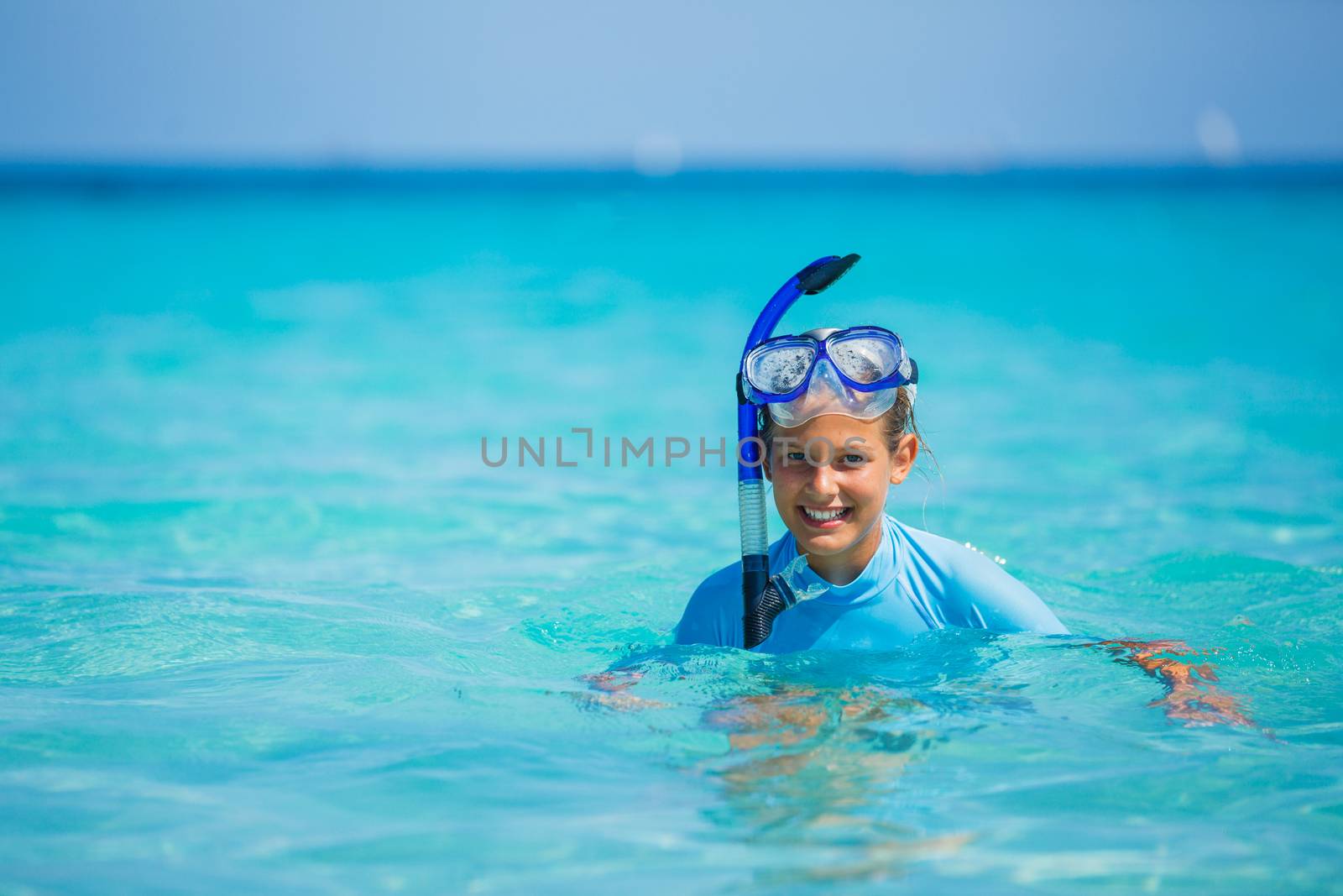 Portrait of happy cute girl wearing snorkeling mask ready to dive in the sea