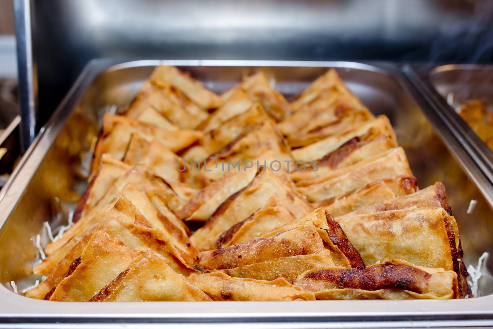 Triangle Crispy Puff pastry in metal tray on buffet line