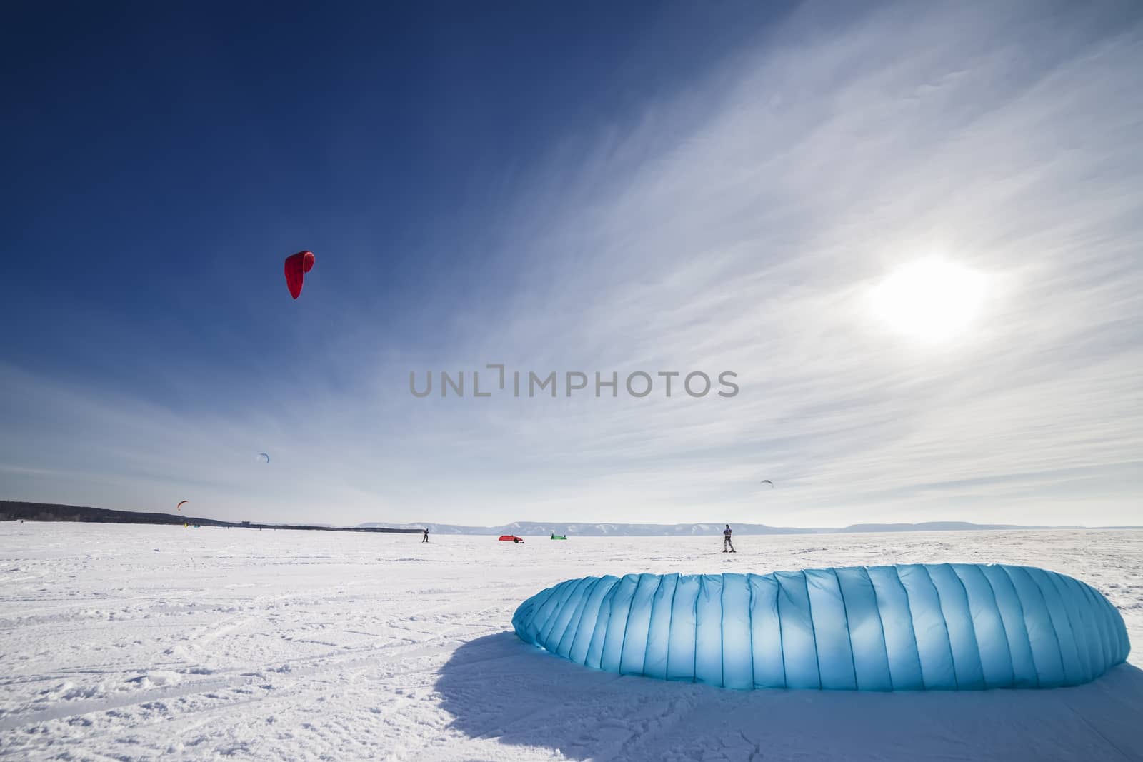 Kite surfer being pulled by his kite across the snow