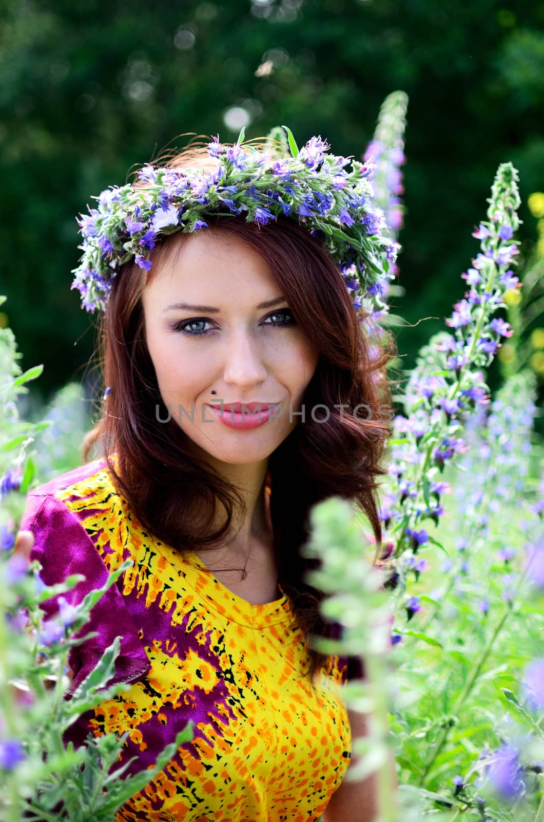 Beautiful girl from Poland with wreath made of flowers. Portrait of female model surrounded by heathers.