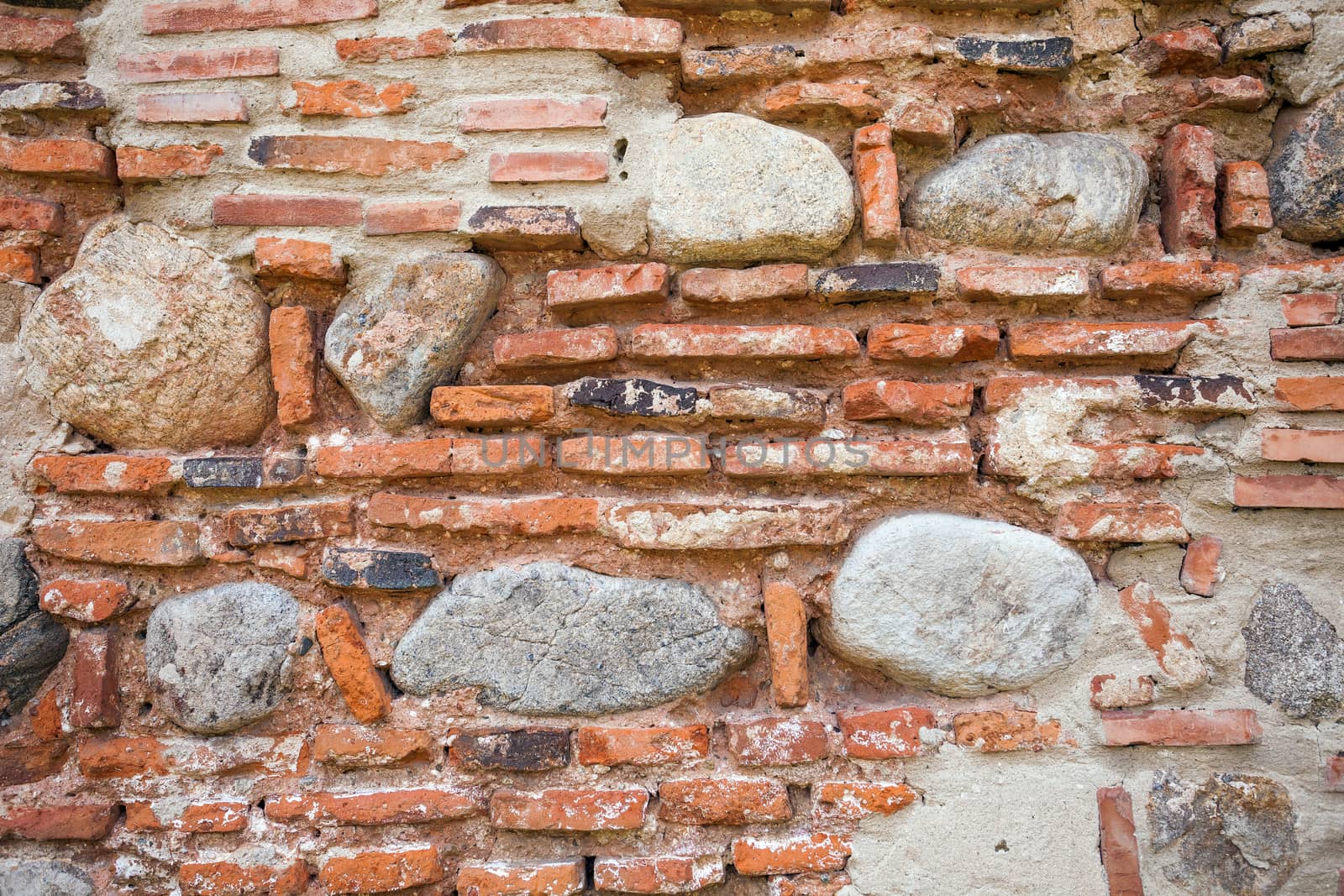 Rustic old wall background made of bricks and stones