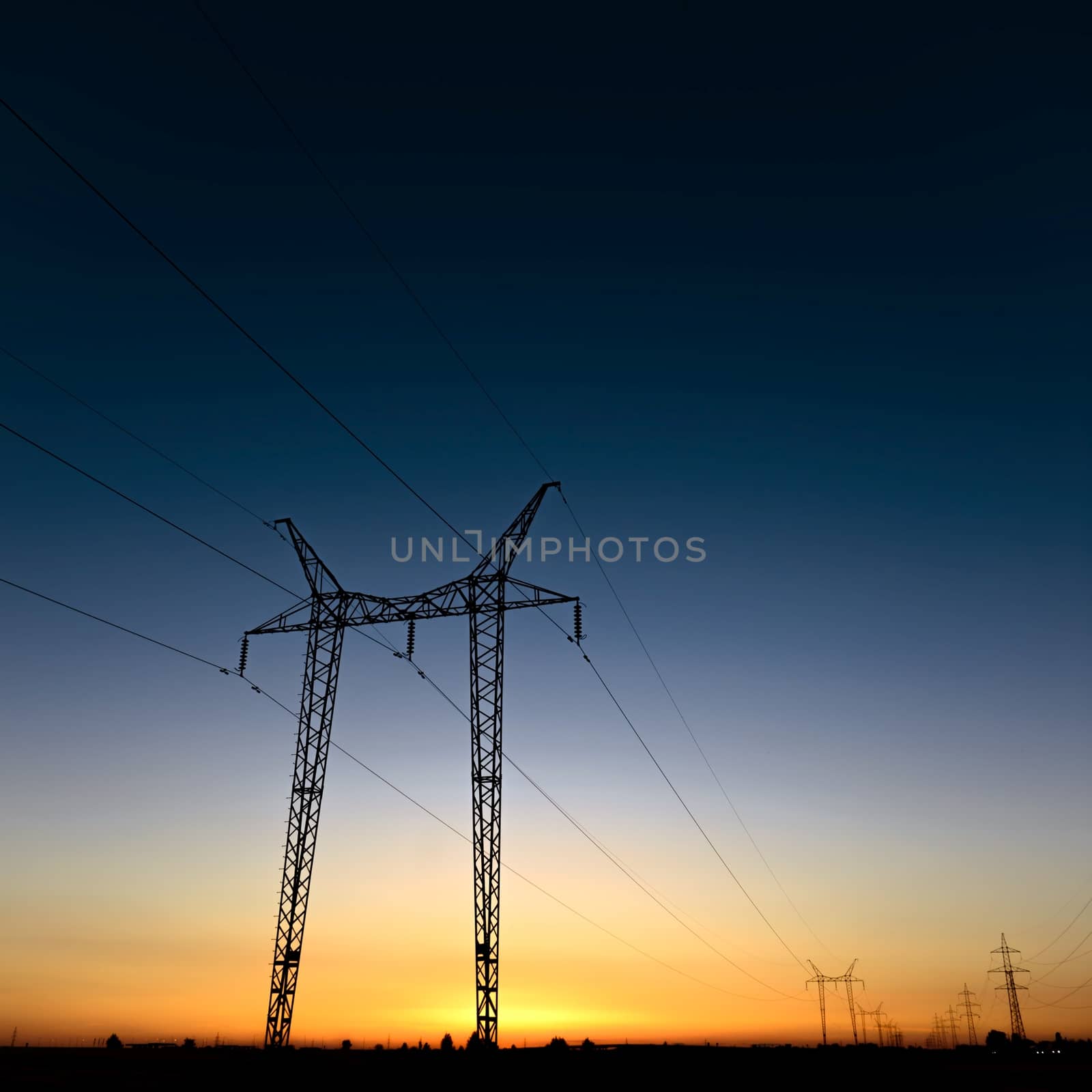 Large transmission towers at blue hour with horizon