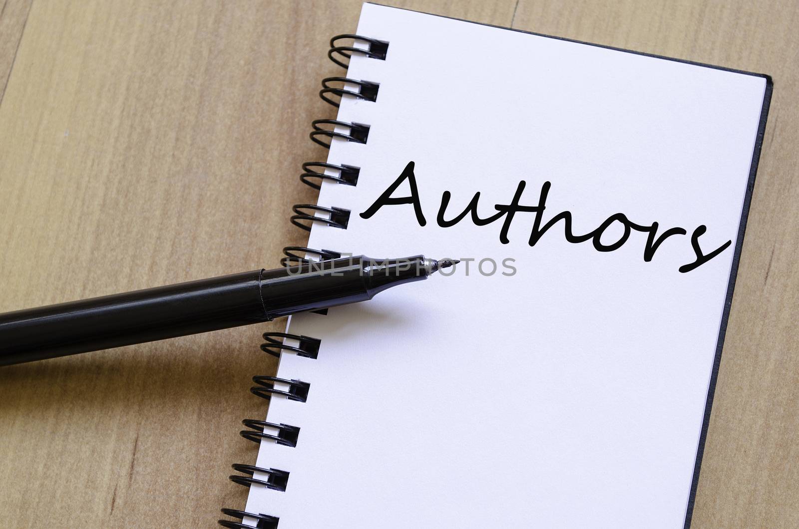 White notepad and ink pen on the wooden desk Authors concept