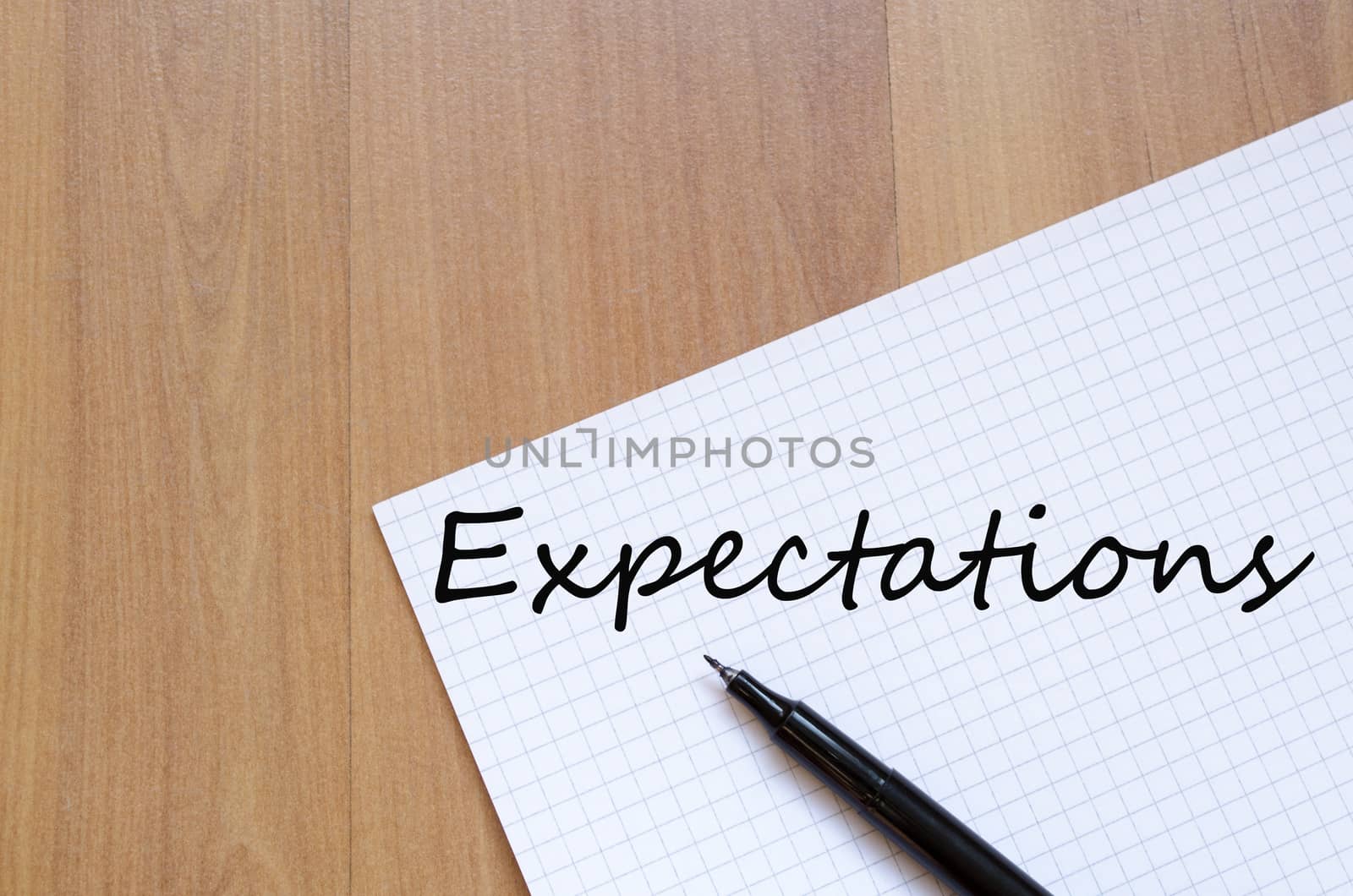 White blank notepad on office wooden table Expectations concept