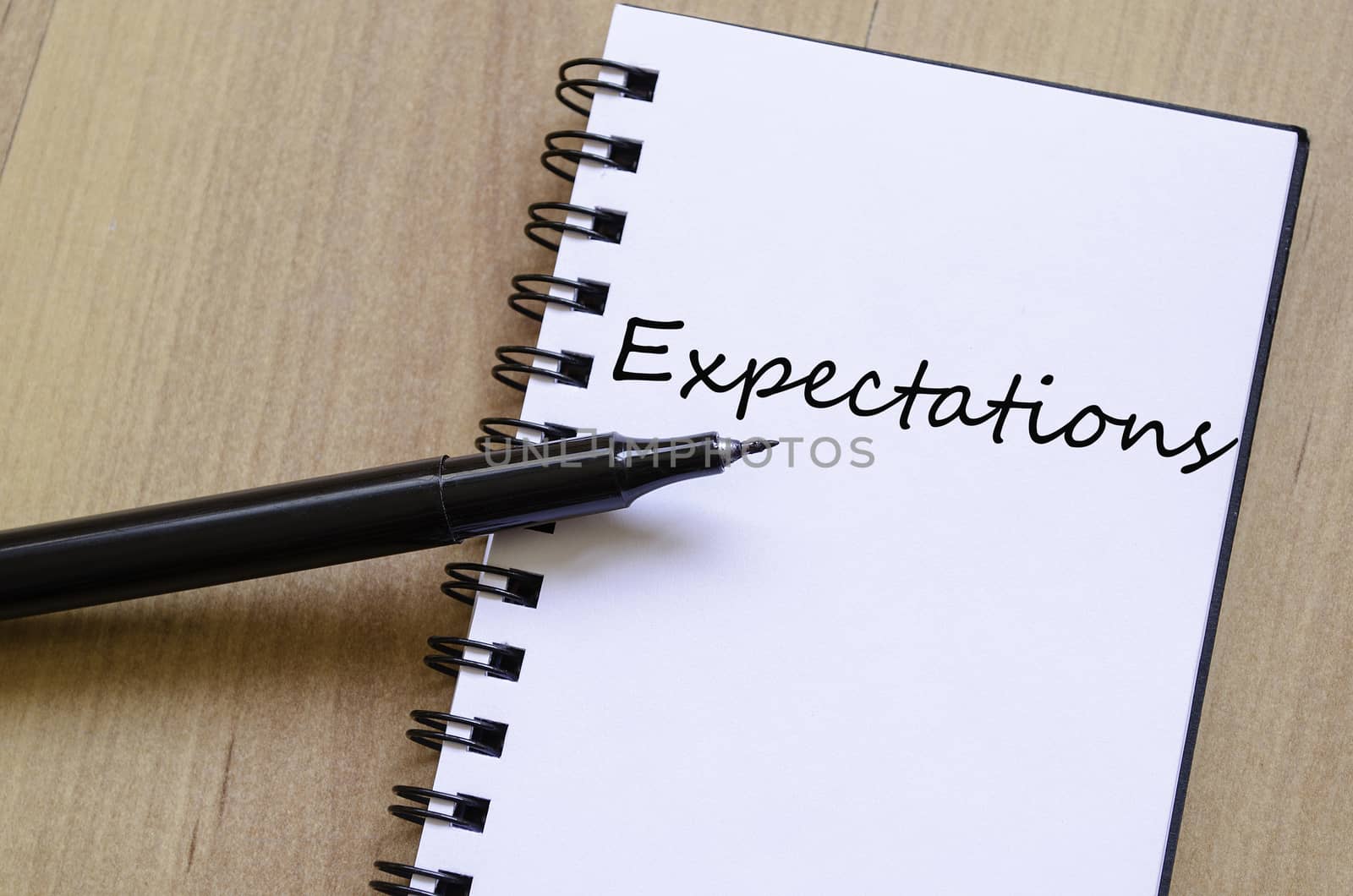 White notepad and ink pen on the wooden desk Expectations concept