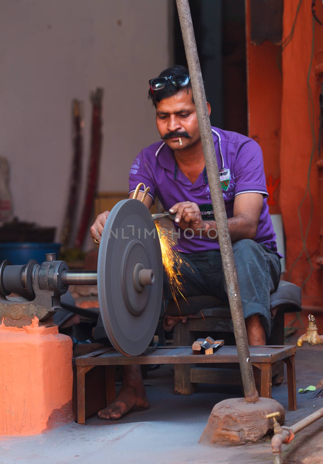 JAIPUR, INDIA - NOVEMBER 18, 2012 :  Street knife grinder at work in Jaipur, Rajasthan, India