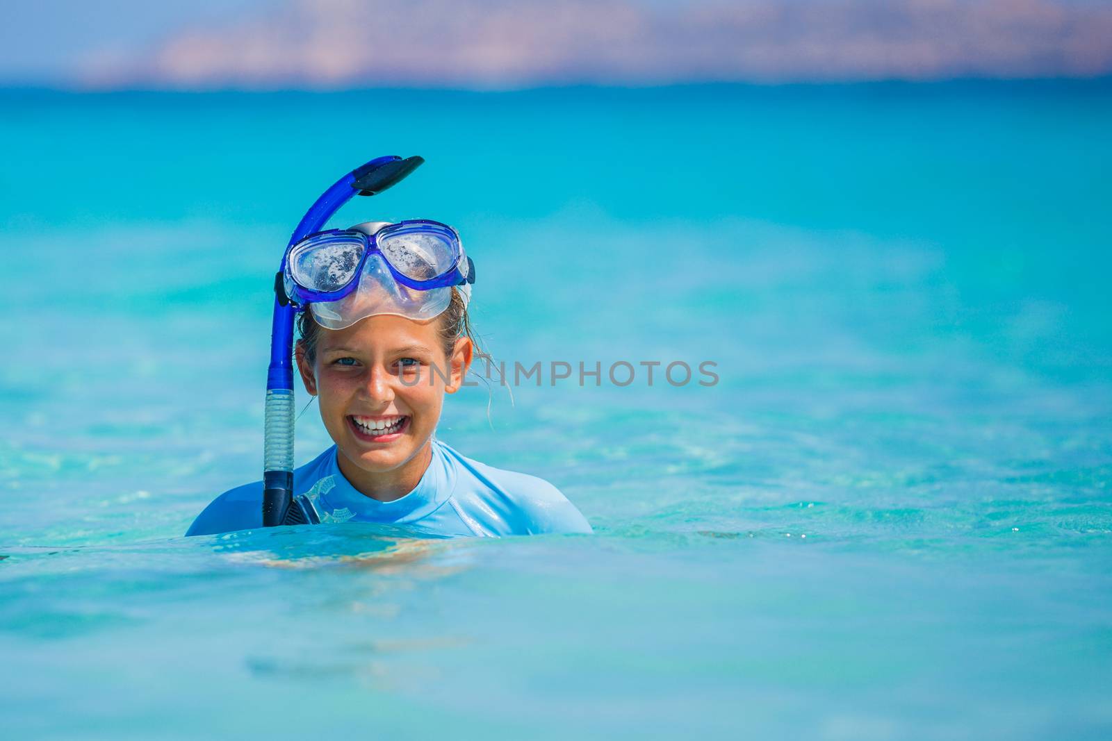 Portrait of happy cute girl wearing snorkeling mask ready to dive in the sea