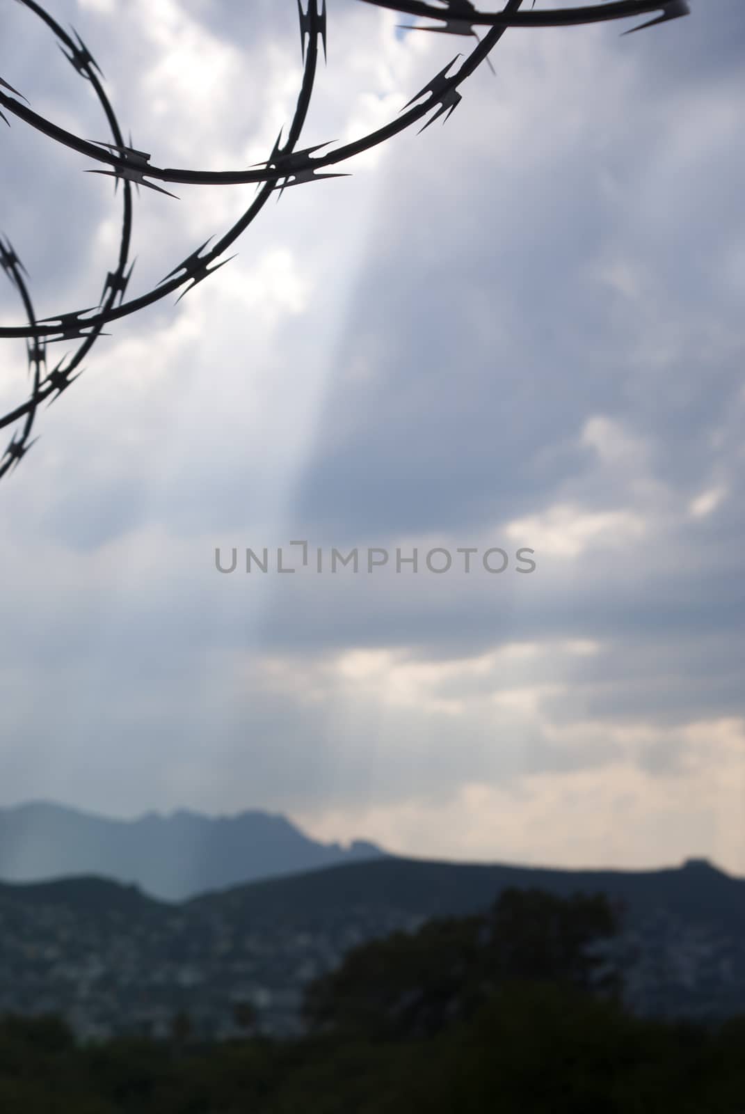 Photograph of a blue cloudy bright sky with a barb wire silhouette