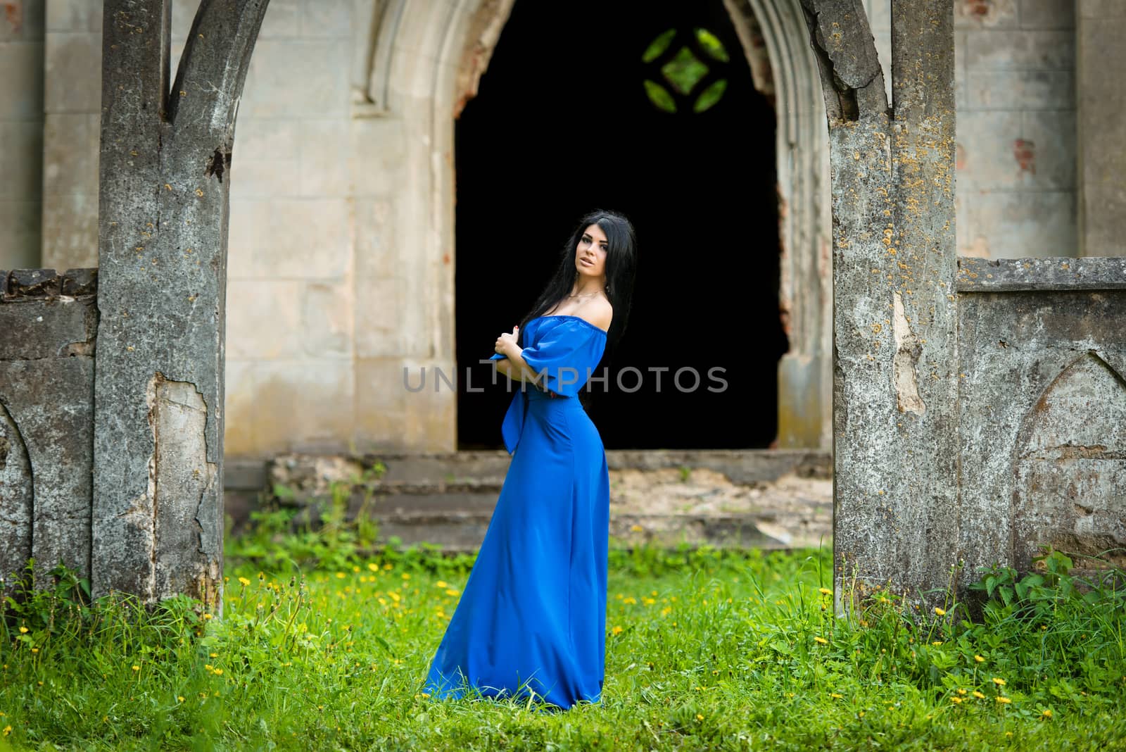 Portrait Of Sensual Fashion Woman In Blue Dress in church ruins