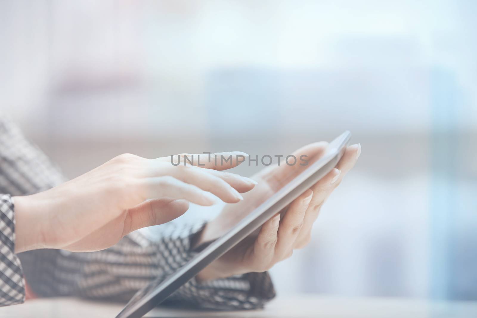Businesswoman at office working with digital PC beinhd the window