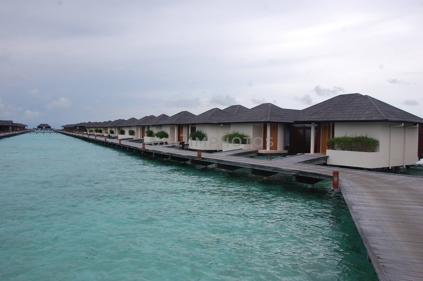 Timber pier with bungalow at island resort in Maldives