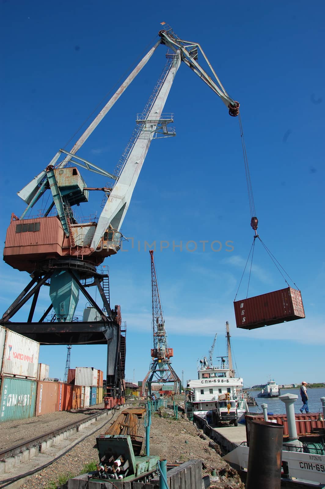 Dockside cargo crane with container at river port, Kolyma, Russia