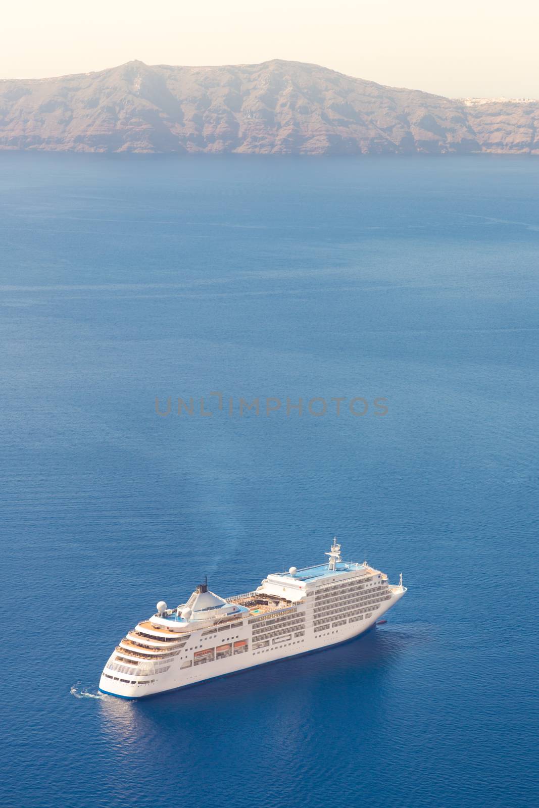 Luxury cruise ship sailing around Santorini island, Aegean sea in Greece.