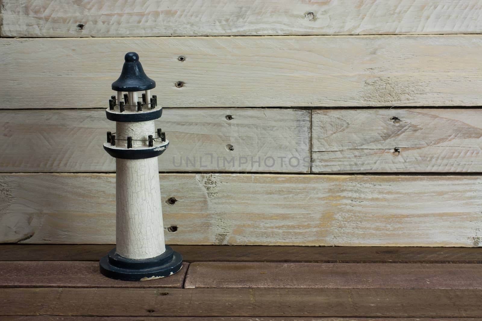 Lighthouse set against a worn wooden background