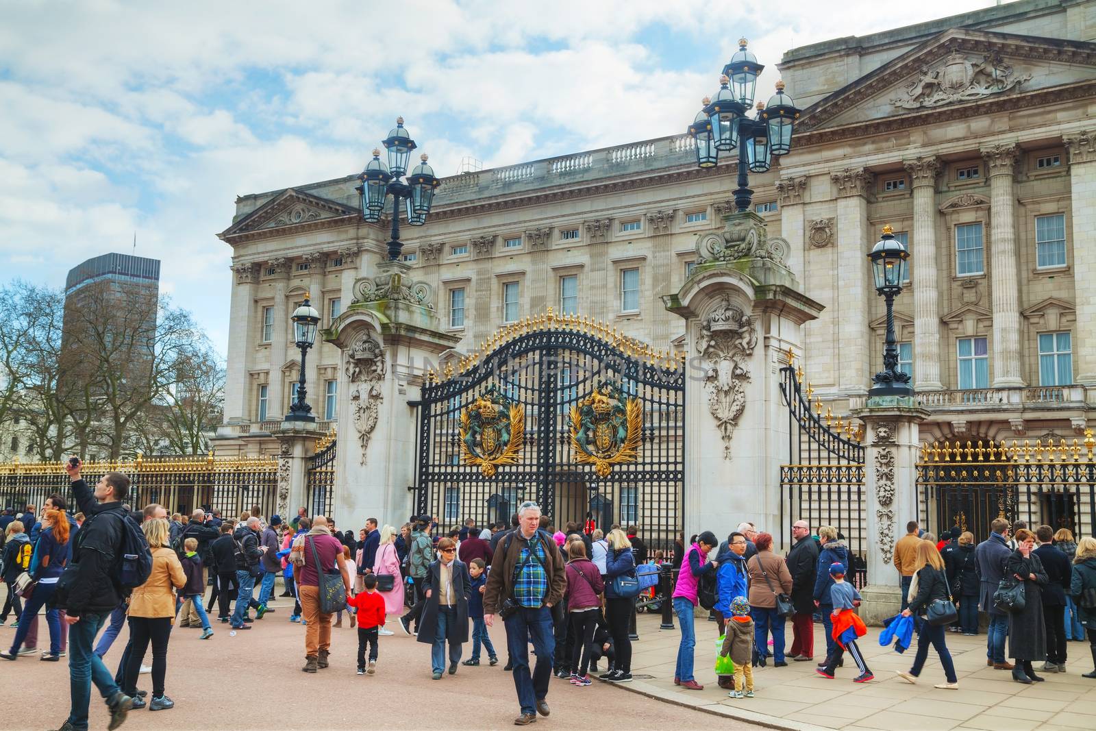 LONDON - APRIL 5: Buckingham palace with crowd of tourists on April 5, 2015 in London, UK. It's the London residence and principal workplace of the monarchy of the United Kingdom.