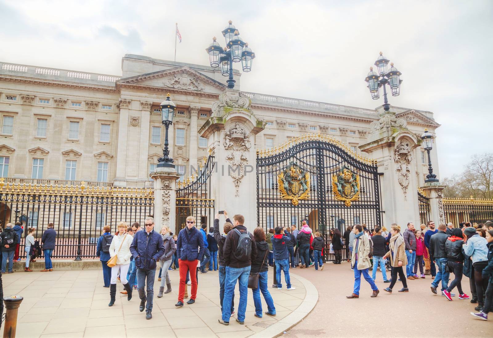 LONDON - APRIL 5: Buckingham palace with crowd of tourists on April 5, 2015 in London, UK. It's the London residence and principal workplace of the monarchy of the United Kingdom.