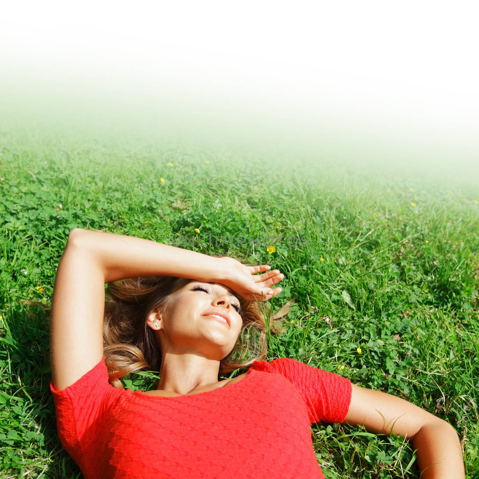 beautiful young woman in red dress lying on grass