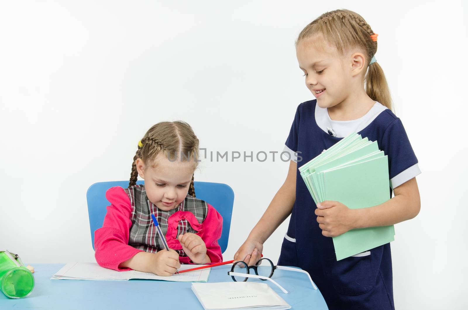 Two girls play school teacher and student