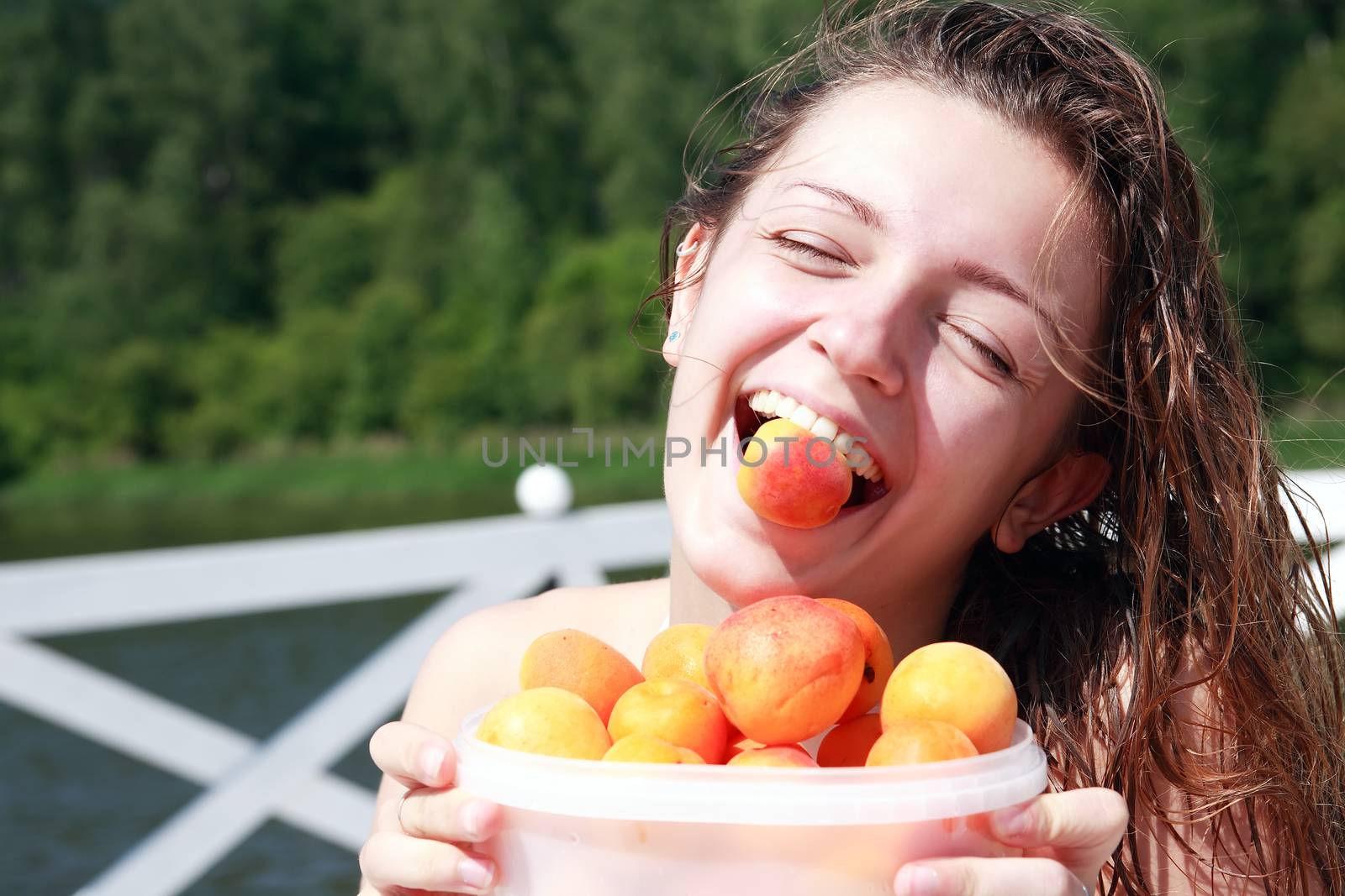 Closeup portrait of smiling beautiful teenage girl with apricots