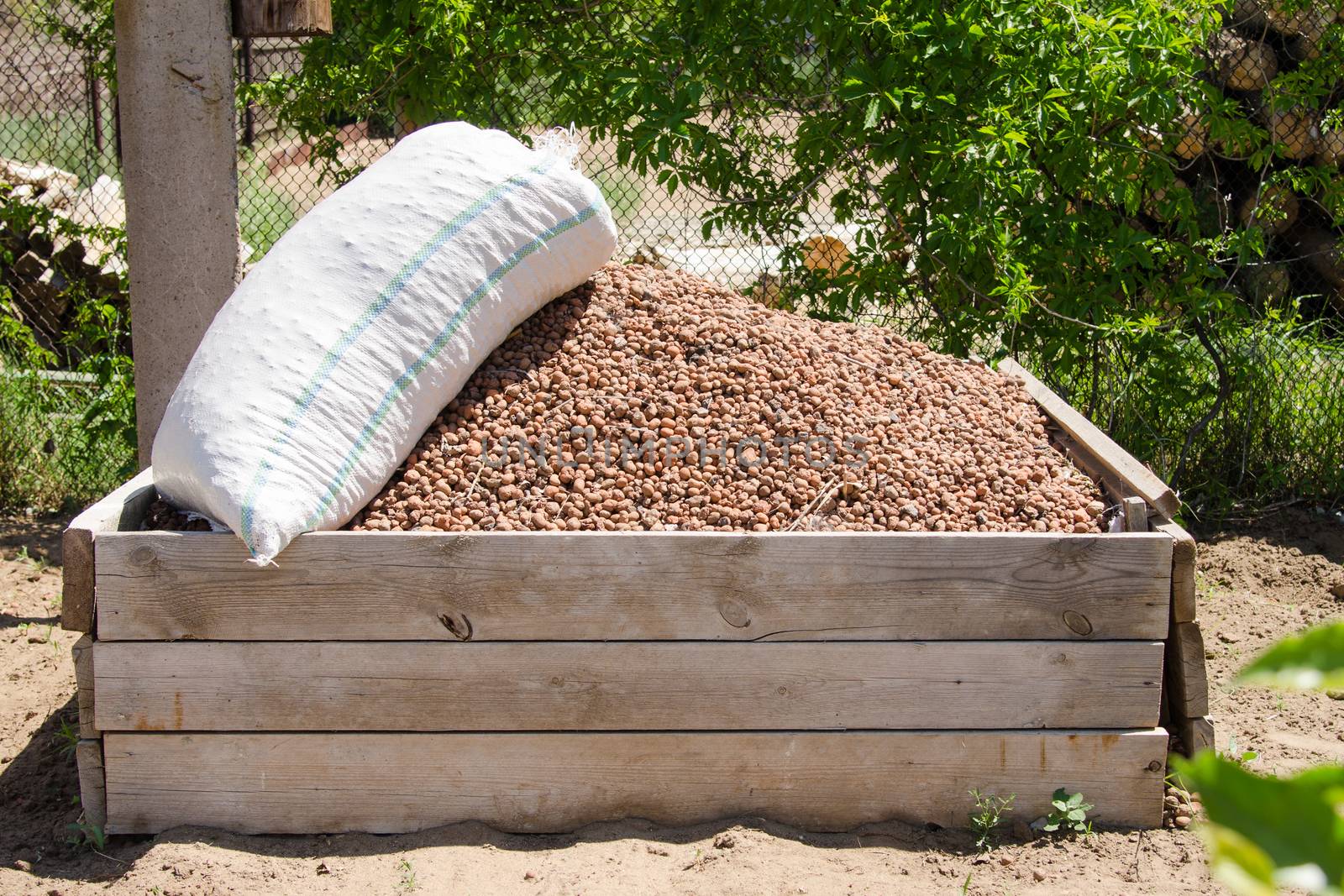 Homemade wooden box with a slide filled expanded clay, expanded clay on top of a sack