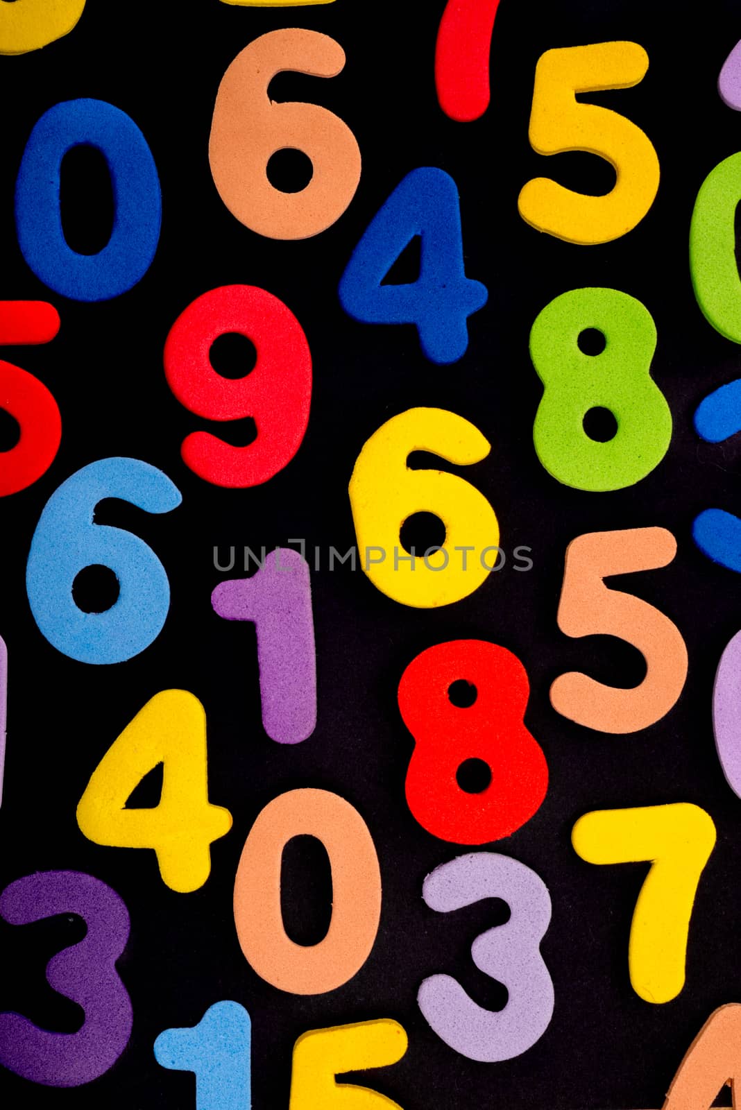 A mix of single digit numbers of different biright colours on a black background.