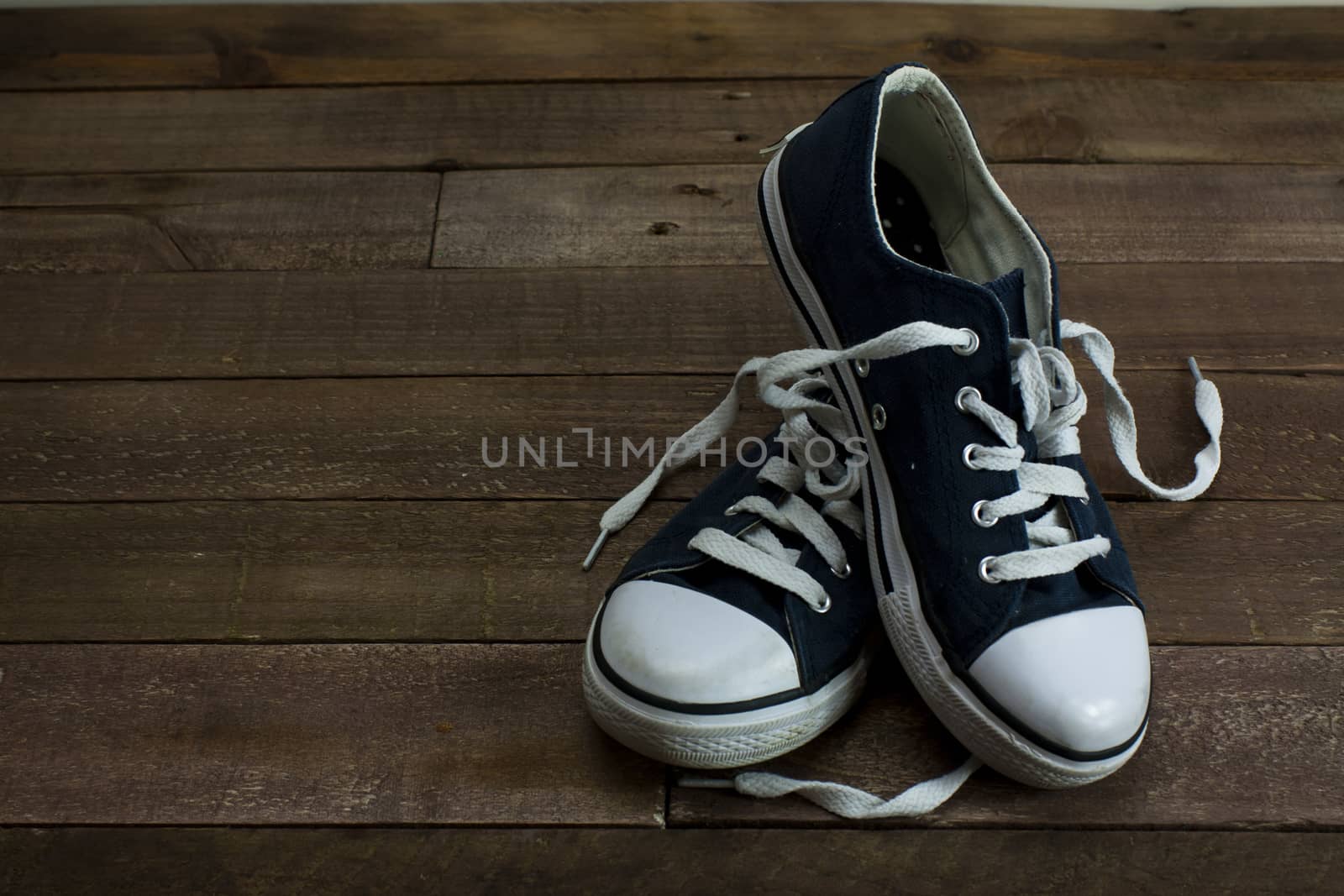 Old shoes on a wooden floor by christopherhall