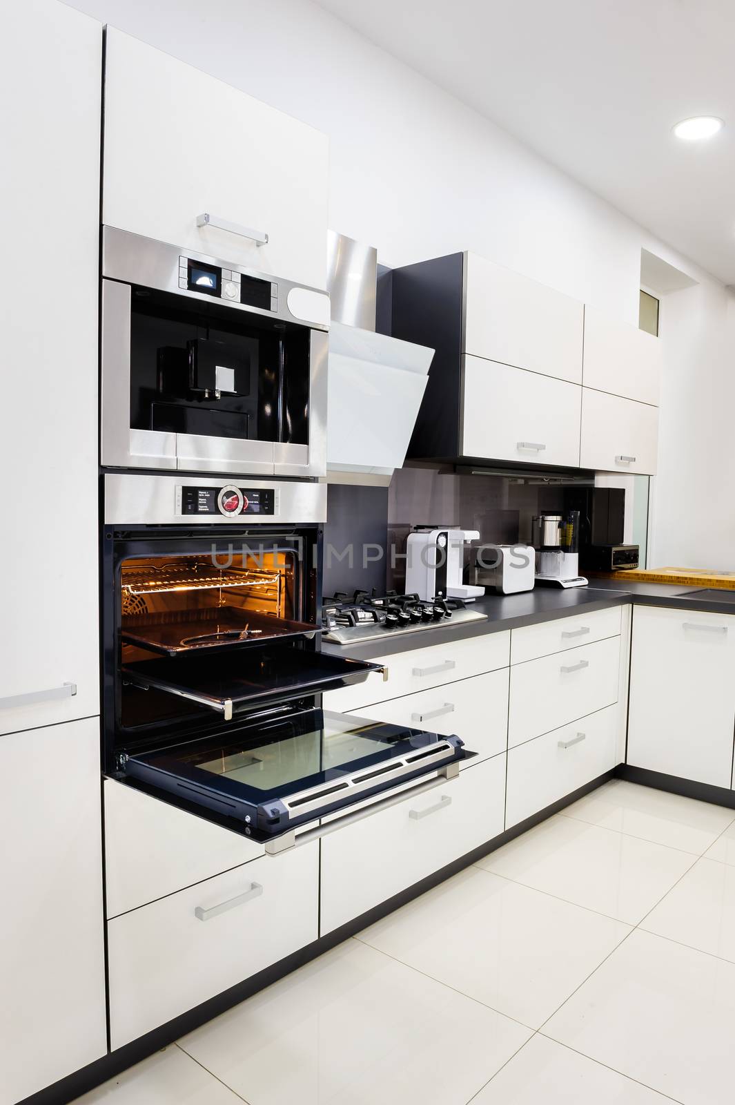 Modern luxury hi-tek black and white kitchen, clean interior design, focu at oven with door open