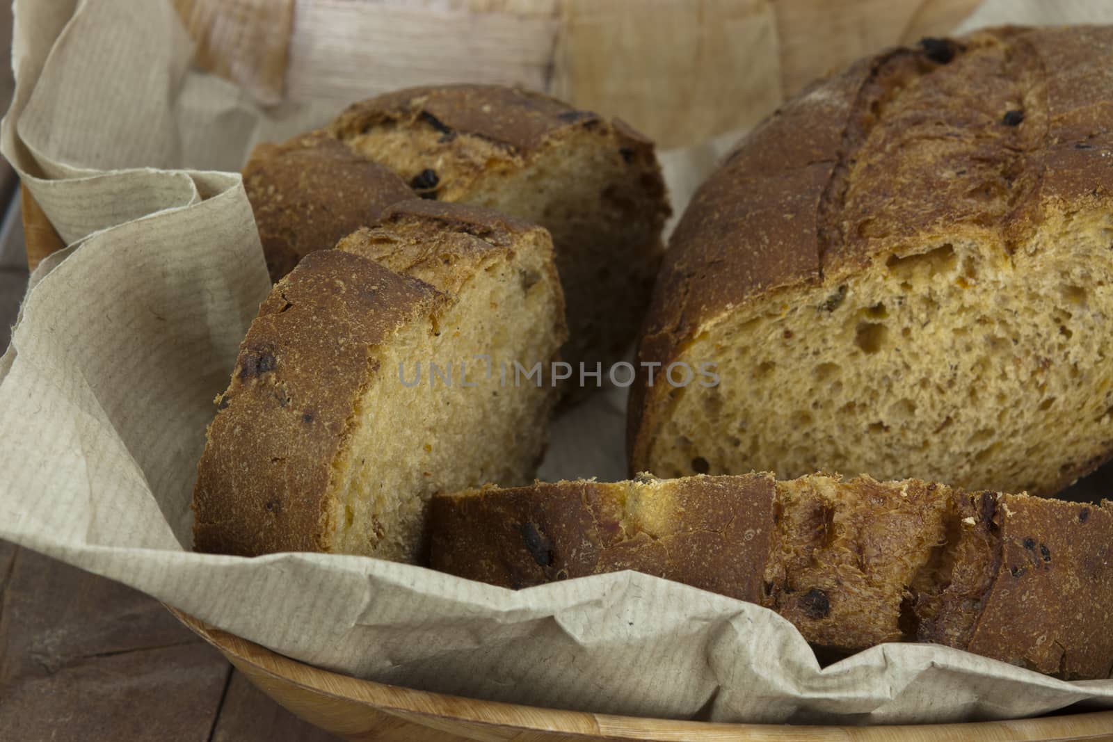 Loaf of wholemeal bread in a basket with brown paper