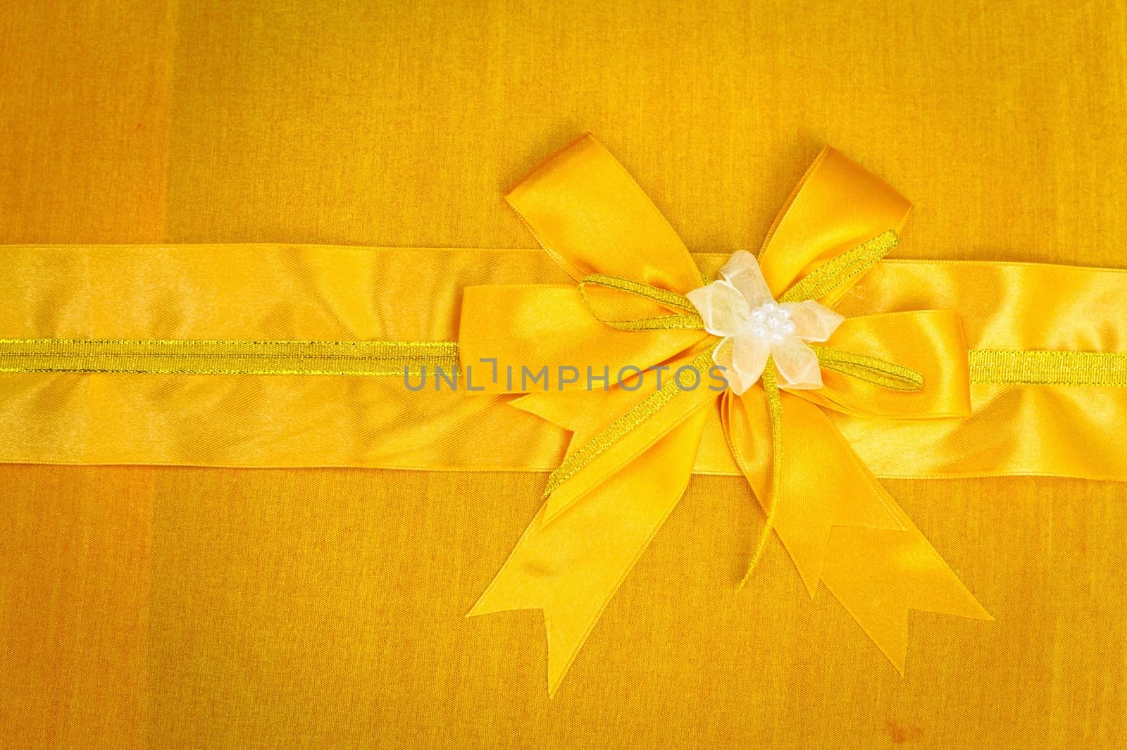 Abstract ribbon bow on fabric background. 