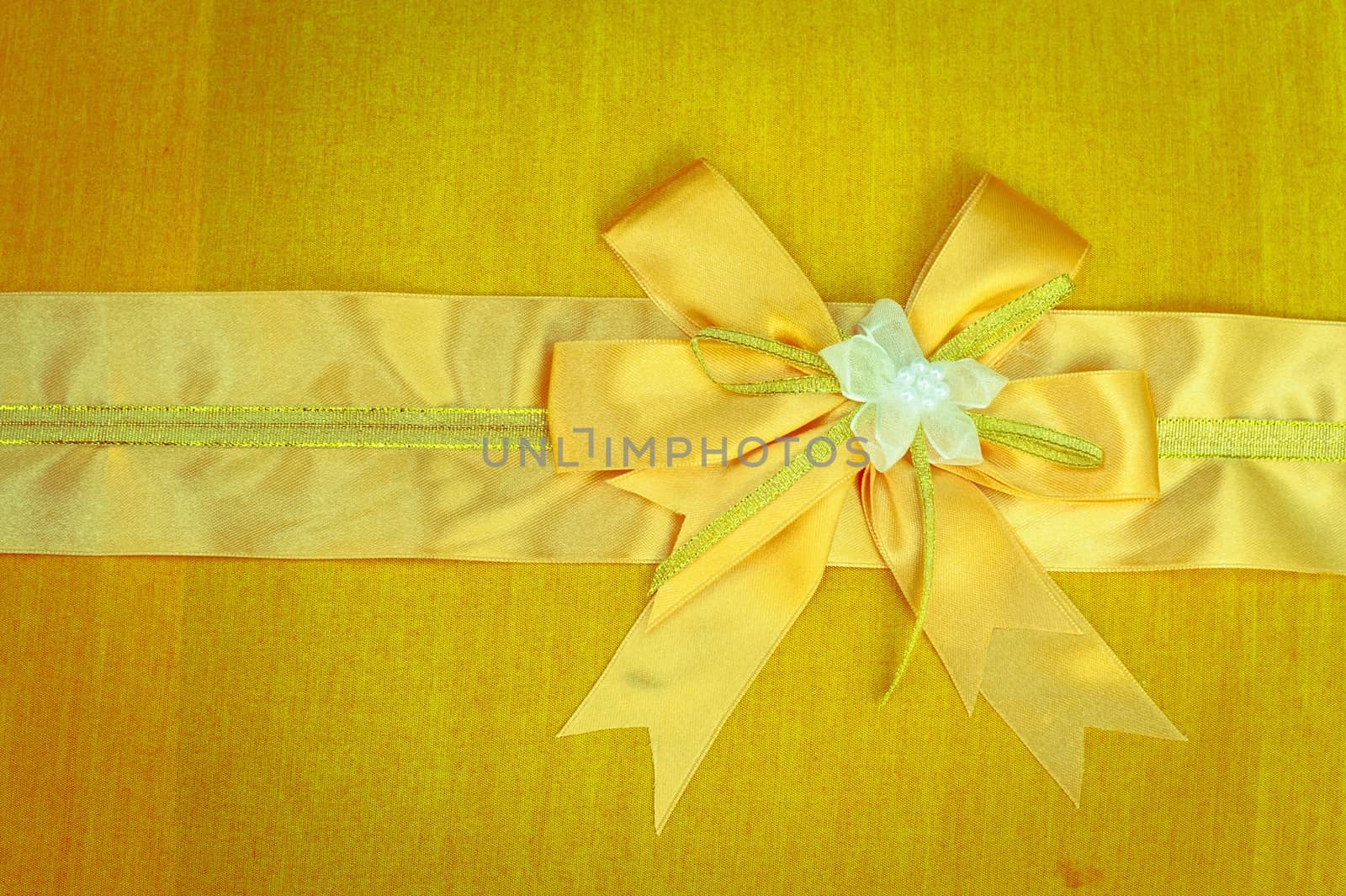 Abstract ribbon bow on fabric background.  by ngungfoto