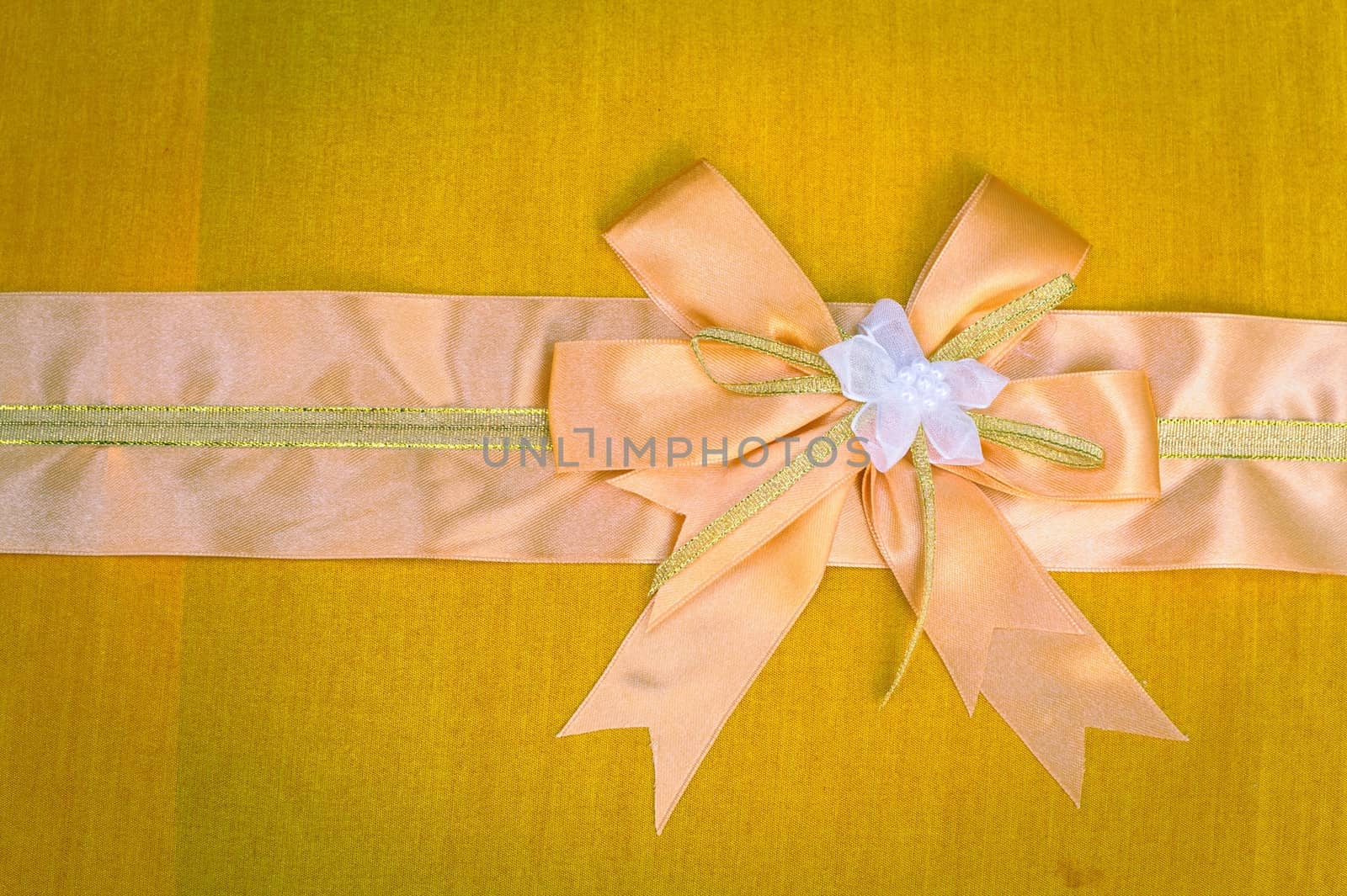 Abstract ribbon bow on fabric background.