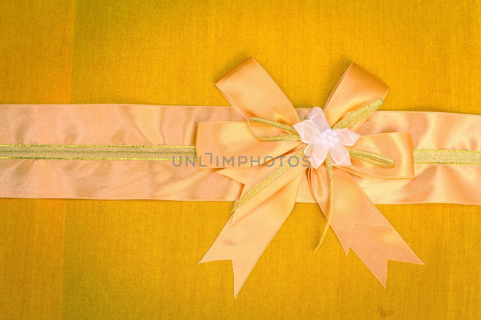 Abstract ribbon bow on fabric background.