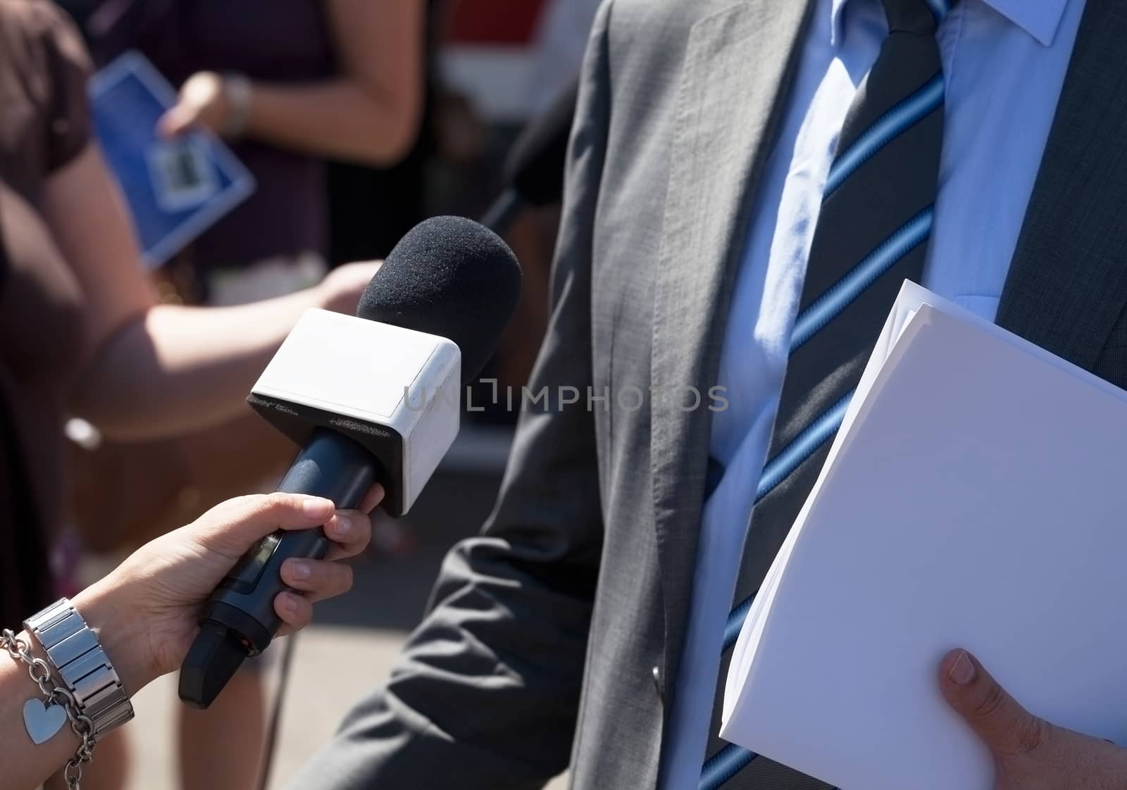 Journalist making media interview with unrecognizable politician or businessman