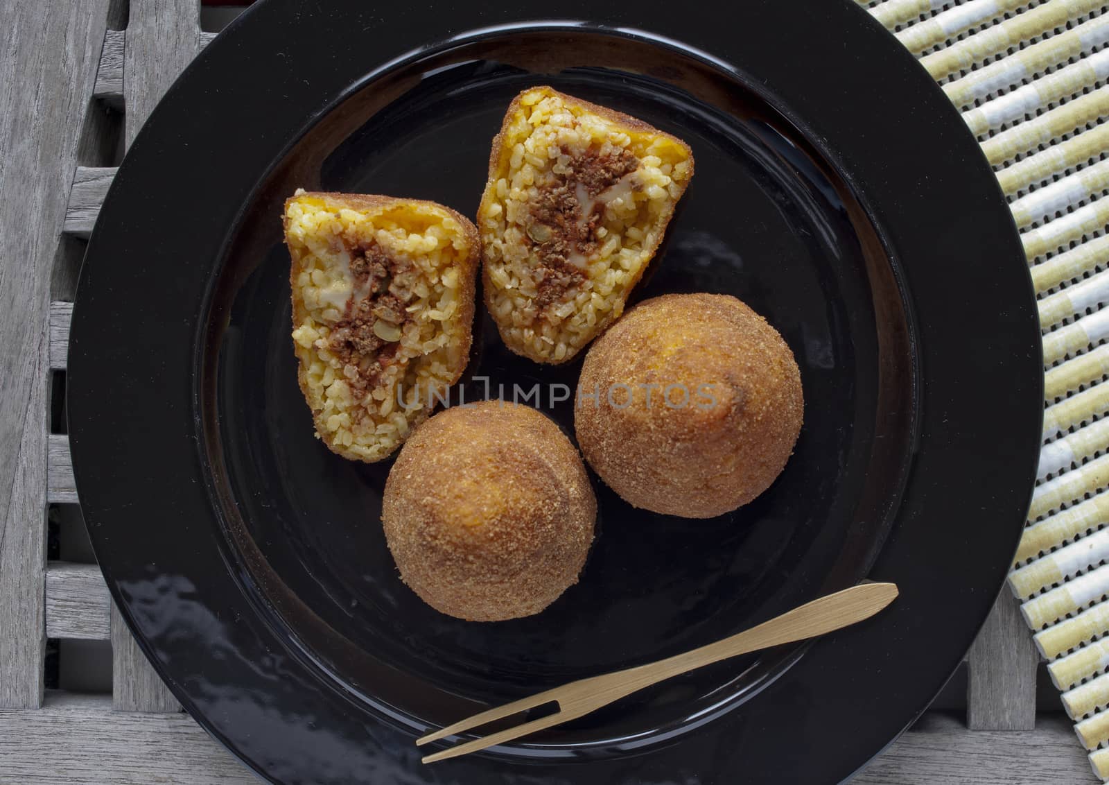 typical italian food: sicilian food called "arancini", made with rice and ragout inside