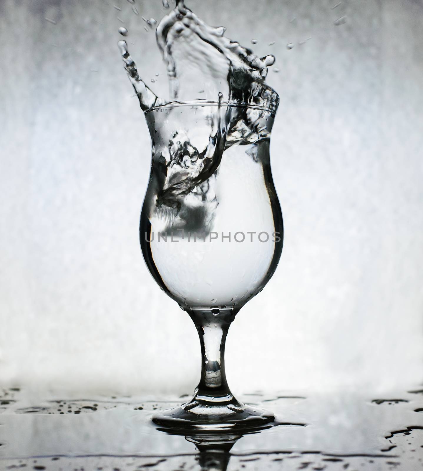 Ice cubes splashing into glass of water, motion blur