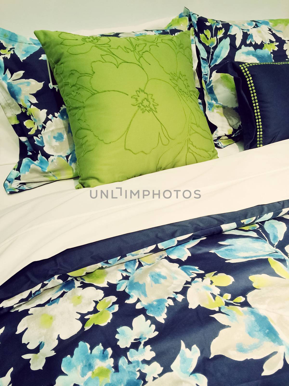 Close-up of a bed. Blue and green bed linen with floral design.