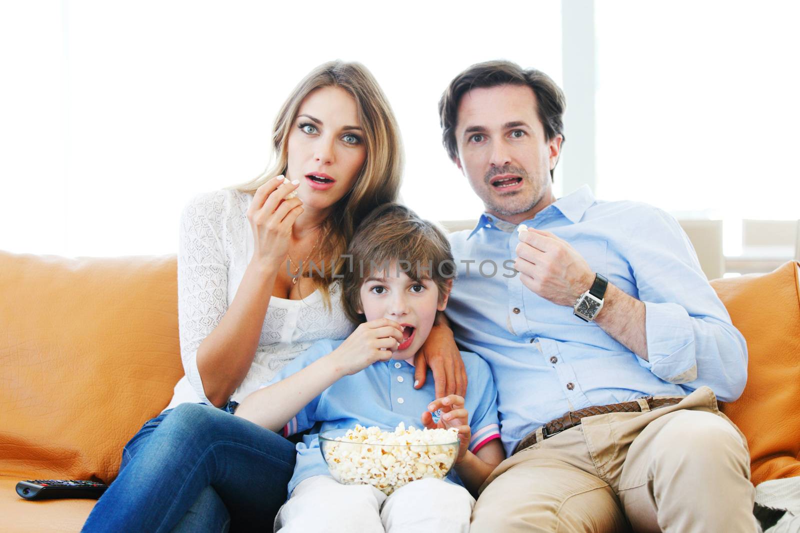 happy family watches movie while sitting on the couch